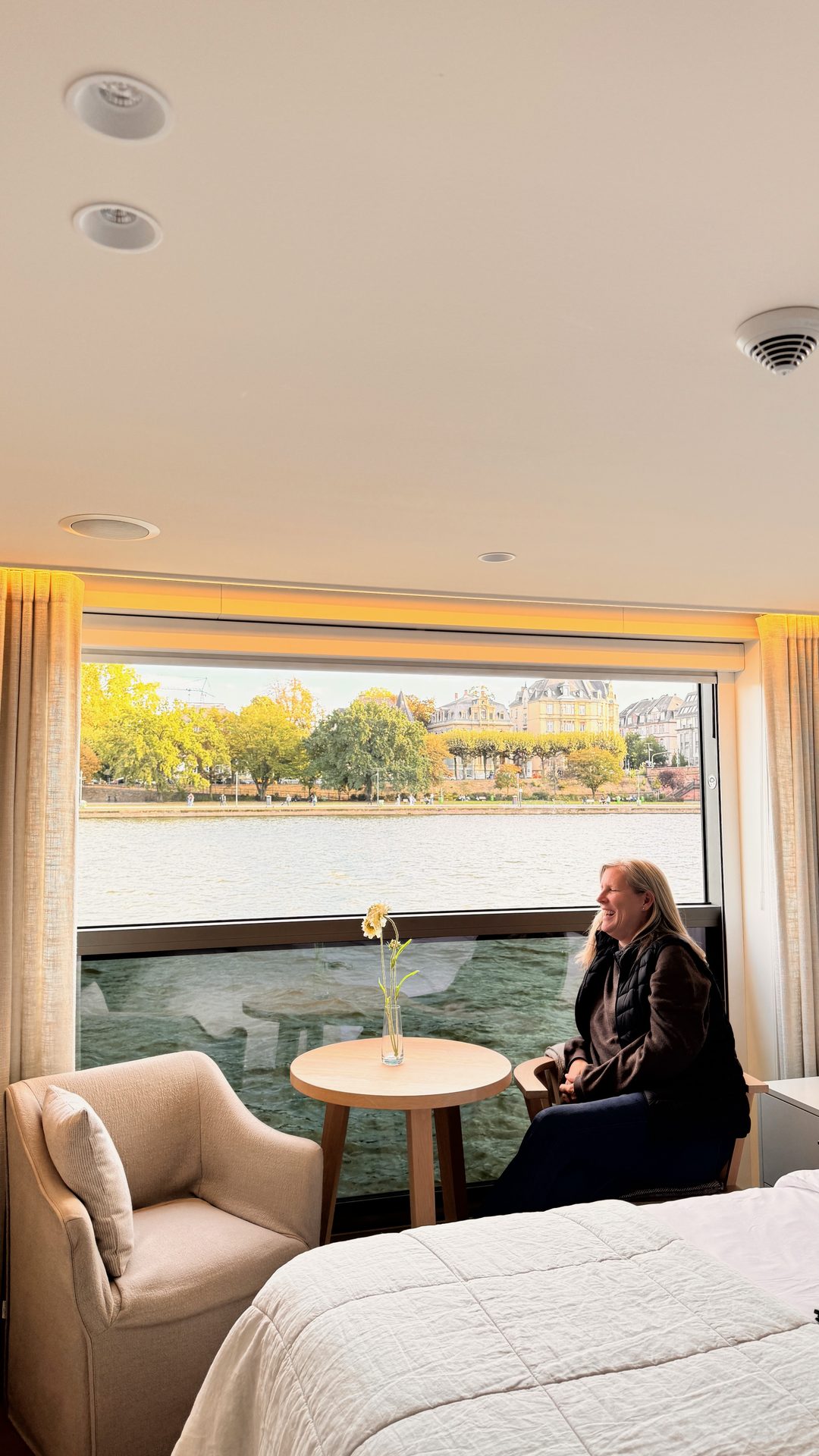 Category A French Balcony Suite on the APT Solara river cruise ship, with a large window that lowers to open the cabin to the river