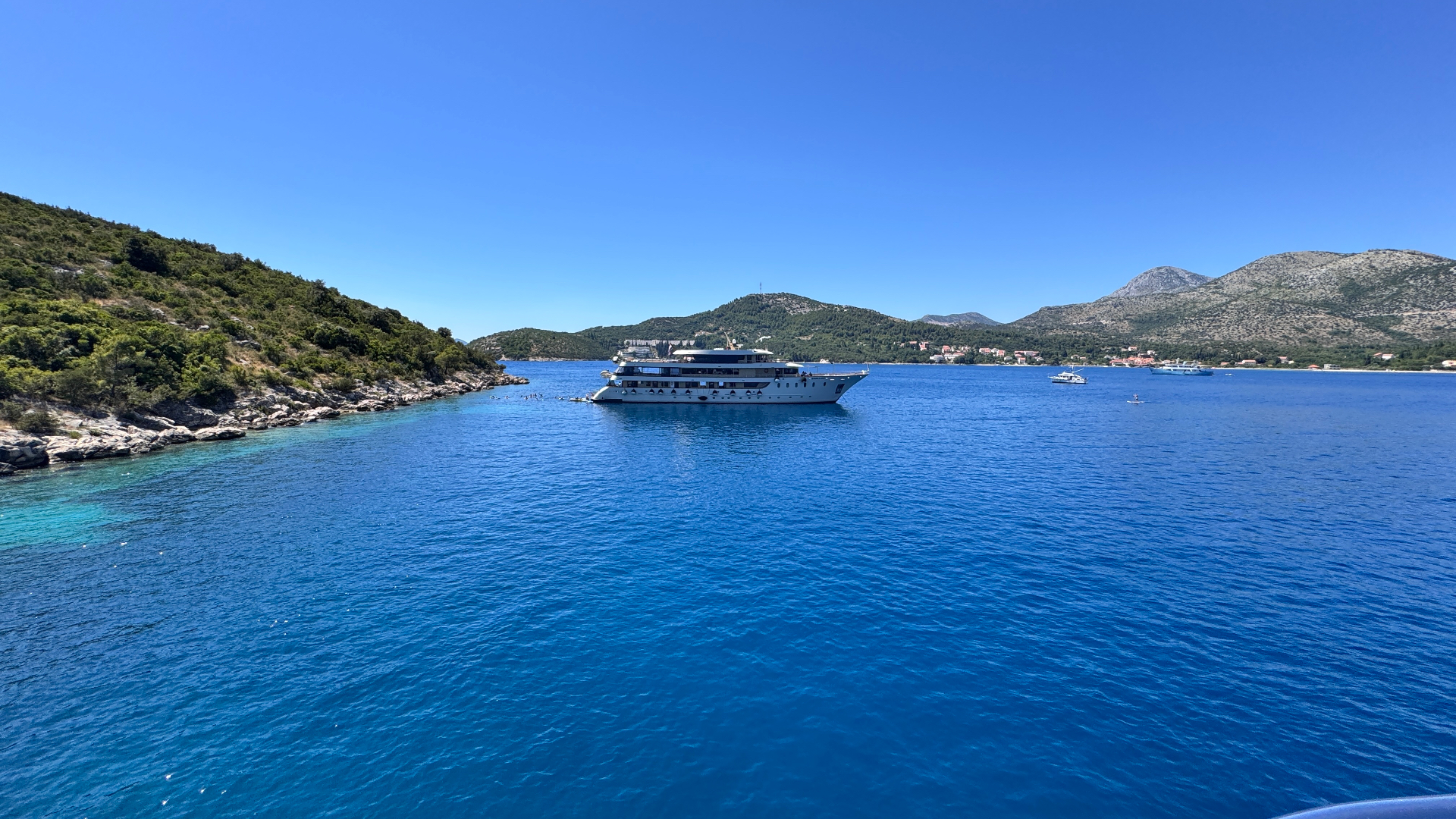 Crystal clear blue waters and cruise ship along the Croatian Adriatic coast
