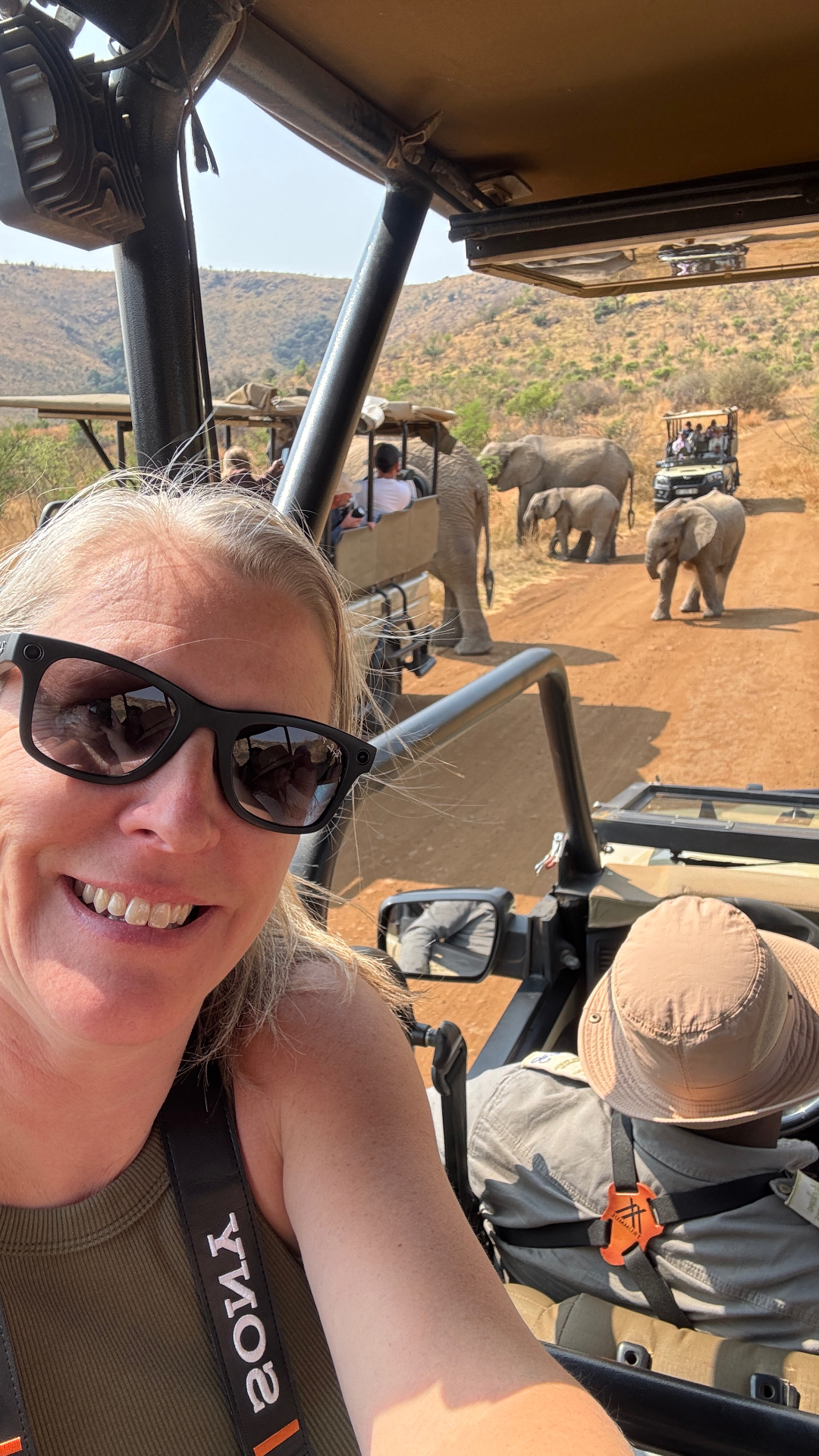 Travel advisor on a safari jeep with elephants crossing the road in South Africa