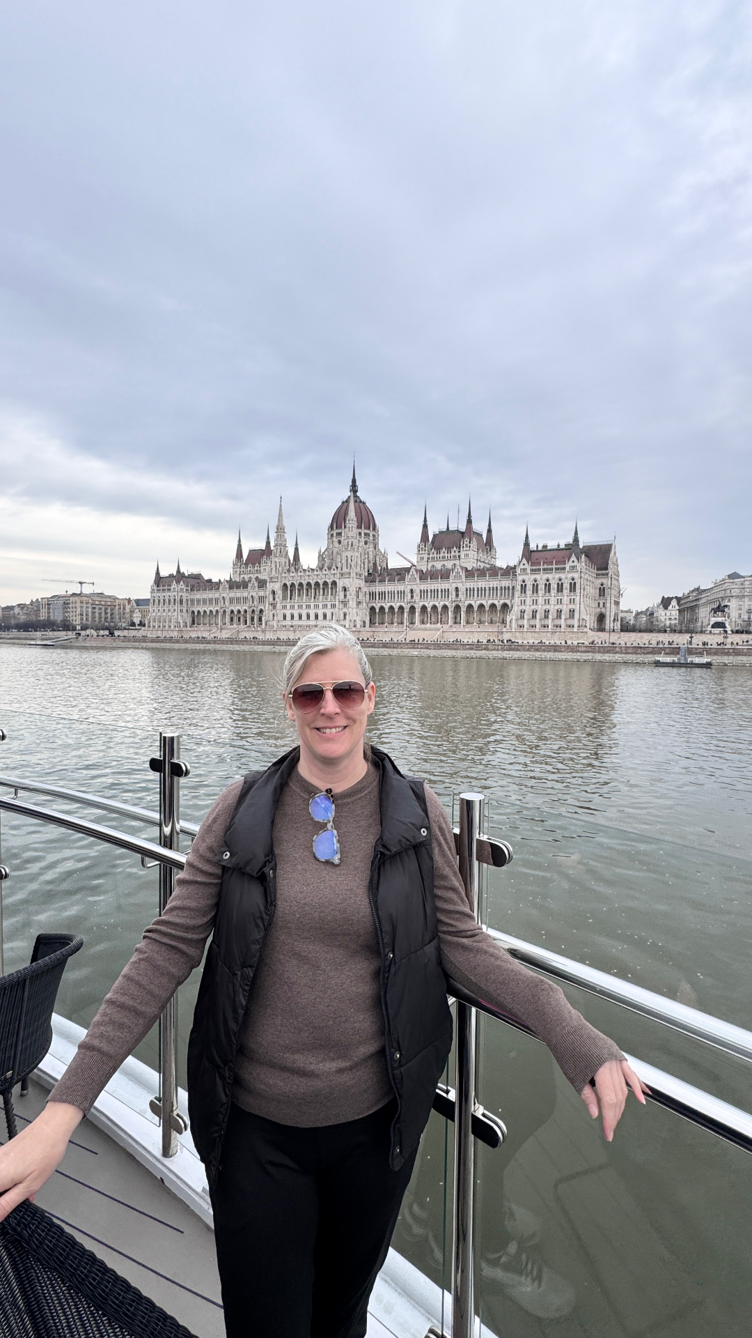 Annie Schlegel travel advisor on a river cruise ship deck with the Hungarian Parliament Building in Budapest - Suite Impressions Travel
