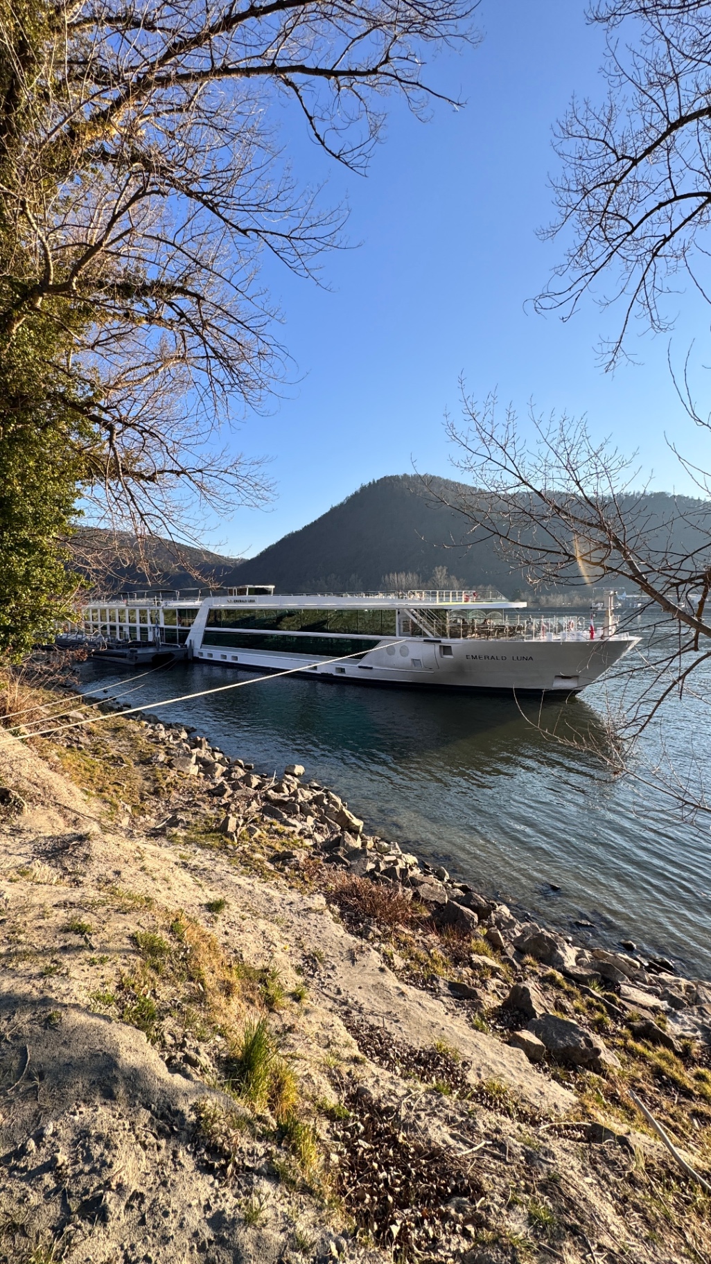 Emerald Luna river cruise ship moored in the Wachau Valley on the Danube with mountain scenery - Suite Impressions Travel
